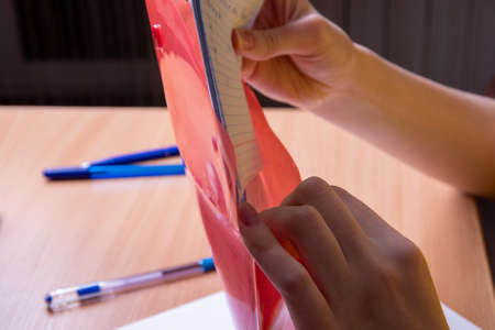 Close-up female hands stack scribbled sheets of paper in pink, red folder, business, training...