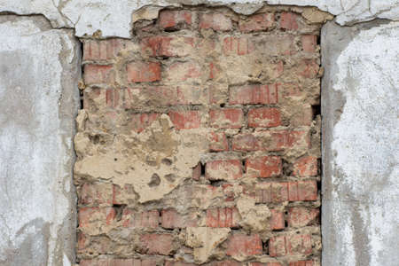 Old gray decorative stucco of the facade of the house in natural scratches and scuffs in the middle of an old orange brickwork. Decorative background, wallpaper, liningの写真素材