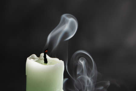 extinct light green candle with spectacular abstract smoke on a black background, close-up, abstraction.の写真素材