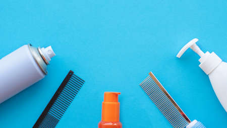 Classic grooming and hairdressing tools on a blue background: varnish, combs, lotions. Top view, layout, copy space.の写真素材