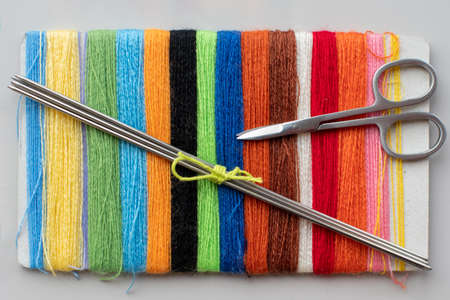 Close-up of multi-colored threads, knitting needles and scissors, top view. The concept of hobbies, creativityの写真素材