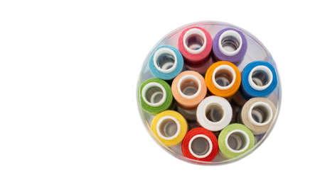 Top view of multi-colored threads in a tube on an isolated background, copy space. Needlework...