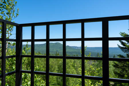 Forged metal fence, observation deck fence, din on a summer mountain landscape. Tourism, travel, adventure, outdoorsの写真素材