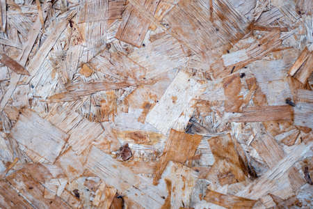Texture of wood-fiber plate of oversipid sawdust. Top view of OSB wood veneer background, tight, seamless surfaces.の写真素材