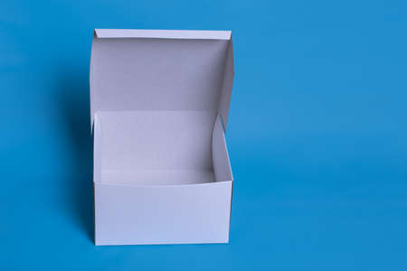 Close up photo of an open white box with shadow on a dark blue background. Clear simple template for packaging design.の写真素材