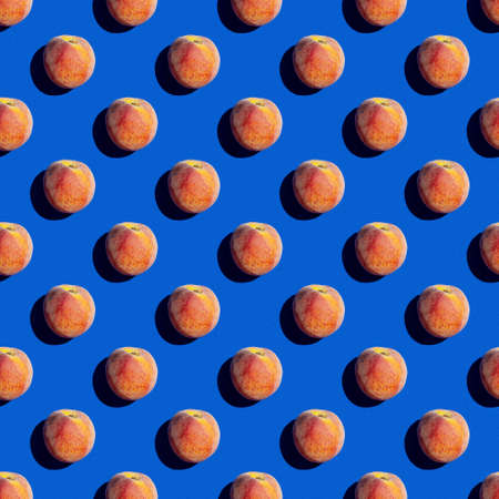 Seamless background - yellow red peach isolated on a classic blue background. Sweets and food topics. Good for wallpaperの写真素材