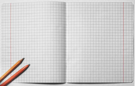 Top view of blank open squared notebook, pen and pencil on white background. Flat lay, copy space.