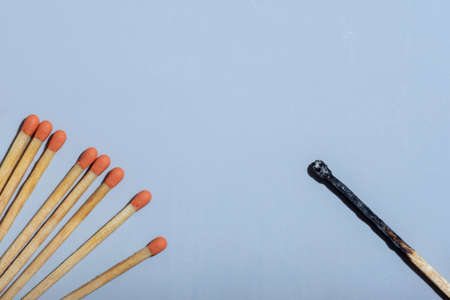 Flat lay orange-headed match on one side and burnt match on the other side, copy space. Business...