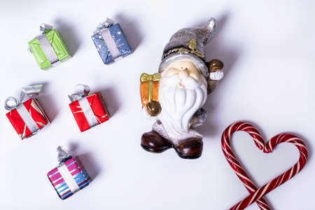 Christmas composition with Santa Claus or gnome, gifts, Christmas candy canes in the shape of a...