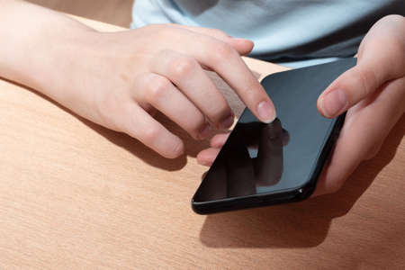 A man holding a smartphone with a black display, a female hand points to a black screen display...