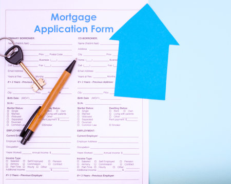 Real estate purchase, mortgage concept. Flat lay mortgage application form, pen and keys to future house or apartment on blue background, top view, copy spaceの写真素材