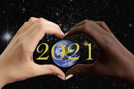 New Year 2021 greeting card. Black and white hands in the shape of a heart with the planet Earth...
