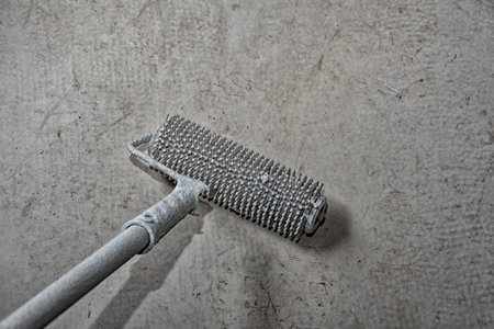 Long handle rubber roller for leveling self-leveling floor. Home repairs. Do it yourself....