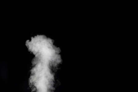 White vapor spray steam from air saturator. Smoke fragments on a black background. Abstract background, design element, for overlay on picturesの写真素材