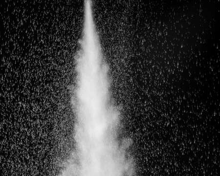 White steam and splashing water on a black background. Abstract background, design elementの写真素材