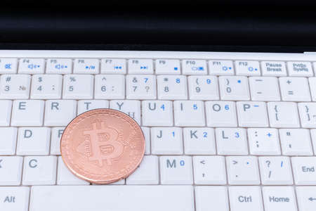 Bitcoin cryptocurrency gold coin on a laptop keyboard . Financial crisis. Digital money. Blockchain technology.の写真素材