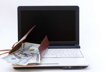 Laptop with blank black screen, open wallet with US dollars on a white background. Internet business concept.の写真素材