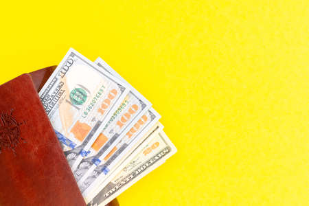 Business success concept. Saving money concept. Dollars in a brown wallet on a bright yellow trending backgroundの写真素材