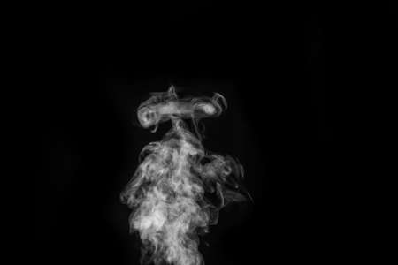 Perfect mystical curly white steam or smoke isolated on black background. Abstract background fog or smogの写真素材
