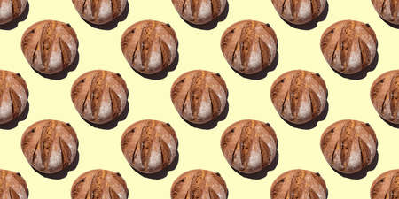 Fresh homemade rustic rye round bread seamless pattern isolated on yellow background, top view.