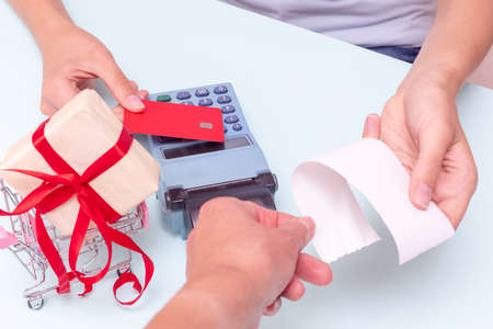 Payment by credit card, bank card at the cash register for the purchase of a gift, the hand giving...