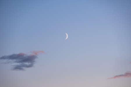 Half Moon in the morning on pink sky with clouds. Dream of a magical evening sky with moon and clouds.の写真素材