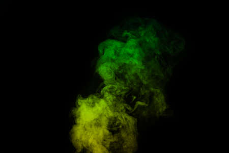 Fragment of green yellow steam smoke isolated on a black background, close-up. Create mystical Halloween photos. Abstract background, design elementの写真素材