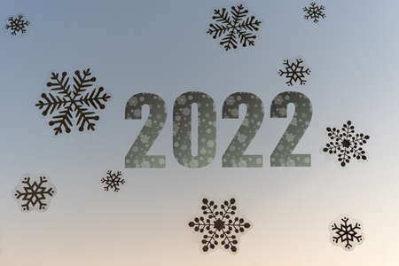 Christmas decoration of the window with white snowflakes stickers and blue inscription 2022