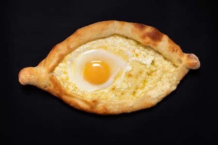 The national Georgian dish is Adjarian khachapuri. Open boat-shaped cheese and egg pie isolated on...