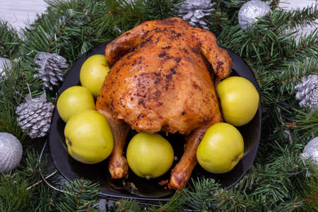 Christmas food. Fried stuffed chicken, turkey with green apples on a festive table with fir branches and Christmas decorationsの写真素材