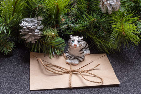 The water tiger is the symbol of the Chinese new year 2022. Toy tiger holding a craft envelope on a...