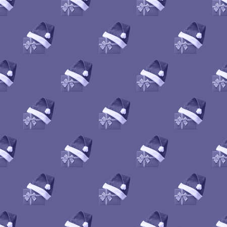 Seamless pattern with tinted gift boxes wearing Santa hat against the 2022 Very Peri trending background.の写真素材