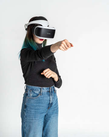 Teenage girl using vr headset punching, fighting with someone in game space, virtual reality on...