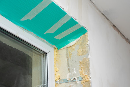 Fragment of a window with a plastic slope made of insulated panels covered with a protective film. Repair of a house or apartment. Finishing with sandwich panels of window slopes. DIY repair.の写真素材
