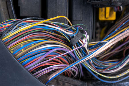 A bundle of electrical wires or cables is strongly mixed up with each other. Remnants of wires of different colors. There are compressed tips on the wires for connectionの写真素材