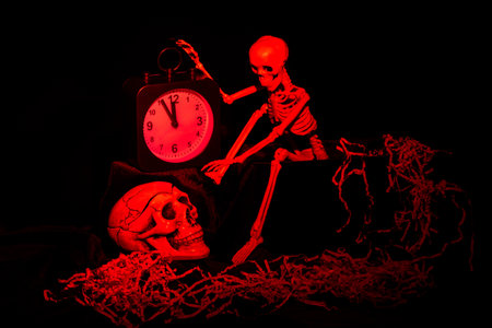 A skeleton waking up, crawling out of the grave and turning off the alarm clock, a skull on a black...