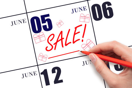 5th day of June. Hand writing text SALE and drawing gift boxes on calendar date June 5. Shopping Reminder. online shopping. Summer month, day of the year concept.の写真素材