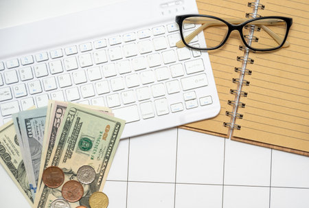 Cash keyboard glasses notepad lying on the table. Workplace of an accountant, financier. View from...