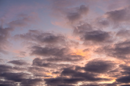 Landscape photo of big, pink cumulonimbus clouds in a stormy sky at sunset. Moody sunset or sunrise...
