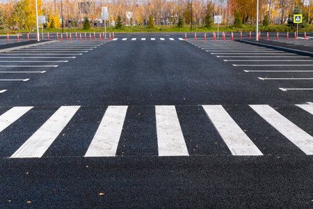 The white and yellow lines of the pedestrian crossing at the intersection of roads in the city. road safety. Zebra road markings, crossing point of the road, traffic rulesの写真素材