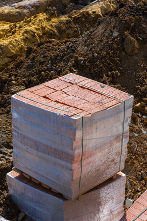 pallets and packages of red bricks in a construction warehouse on the street. Building material red...