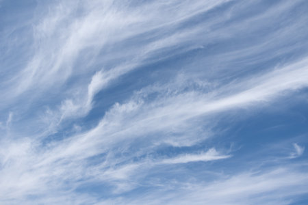 Unusual white striped wavy clouds in a bright blue sky. Heavenly background for your photos. Perfect...