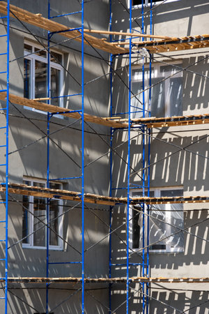 Building under construction with scaffolds. The process of renovating a new building. New...