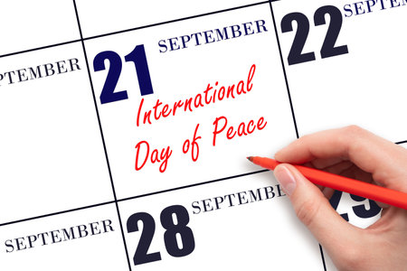 September 21. Hand writing text International Day of Peace on calendar date. Save the date. Holiday. Important date. Day of the year concept.の写真素材