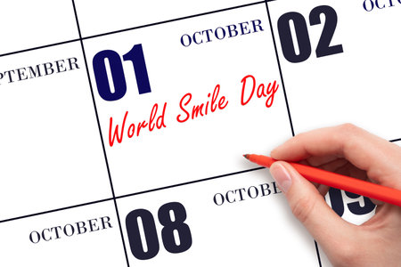 October 1. Hand writing text World Smile Day on calendar date. Save the date. Holiday. Important date. Day of the year concept.の写真素材