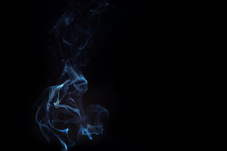Blue smoke swirls in abstract form, photography style on black background. Concept of mystery and creativity. Swirling, writhing smoke to overlay on your photos.の写真素材