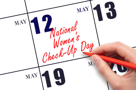 May 12. Hand writing text National Women's Check-Up Day on calendar date. Save the date. Holiday. Planning or scheduling concept.の写真素材