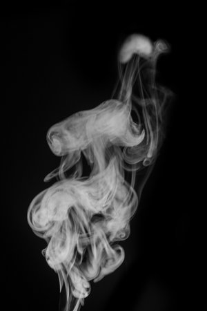 Wisps of ethereal smoke swirl gracefully against a dark background, creating a captivating visual experience that embodies smoke artの写真素材