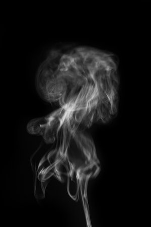 Ethereal wisps of smoke swirling gracefully against a dark background creating a captivating visual experience smoke art concept. graphic resource for montage, overlay or texture.の写真素材