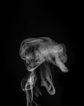 Ethereal smoke swirling gracefully in the air creating abstract shapes and patterns for artistic expression concept. graphic resource for montage, overlay or texture.の写真素材